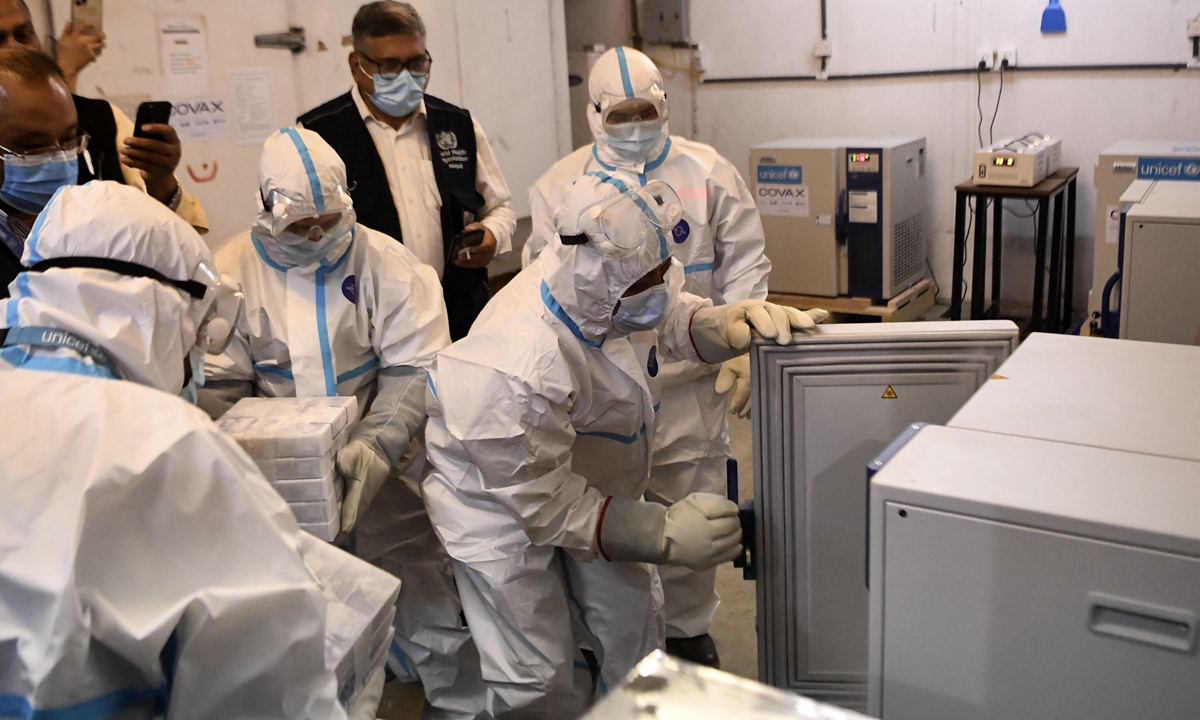 Workers wearing Personal Protective Equipment (PPE) suits prepare to handle the consignment of the Pfizer-BioNTech vaccines against COVID-19 donated to Nepal by the US government at a cold storage facility in Kathmandu on Monday. Photo: AFP