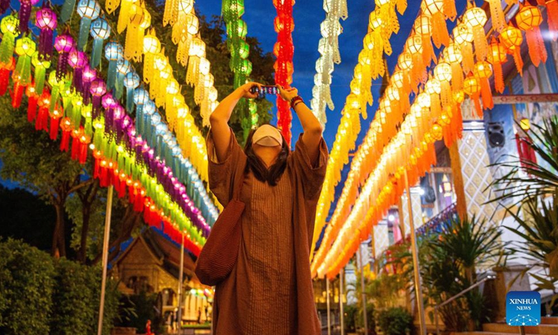 A tourist takes photos of lanterns at the Wat Phra That Hariphunchai in Lamphun, Thailand, Oct. 25, 2021.Photo:Xinhua