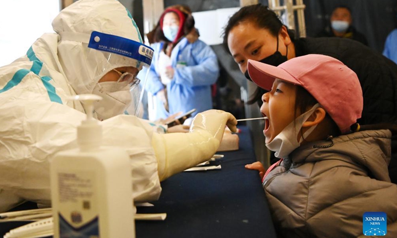 A staff member takes a swab sample from a child for nucleic acid test at a testing site in Harbin, northeast China's Heilongjiang Province, Oct. 30, 2021.Photo:Xinhua