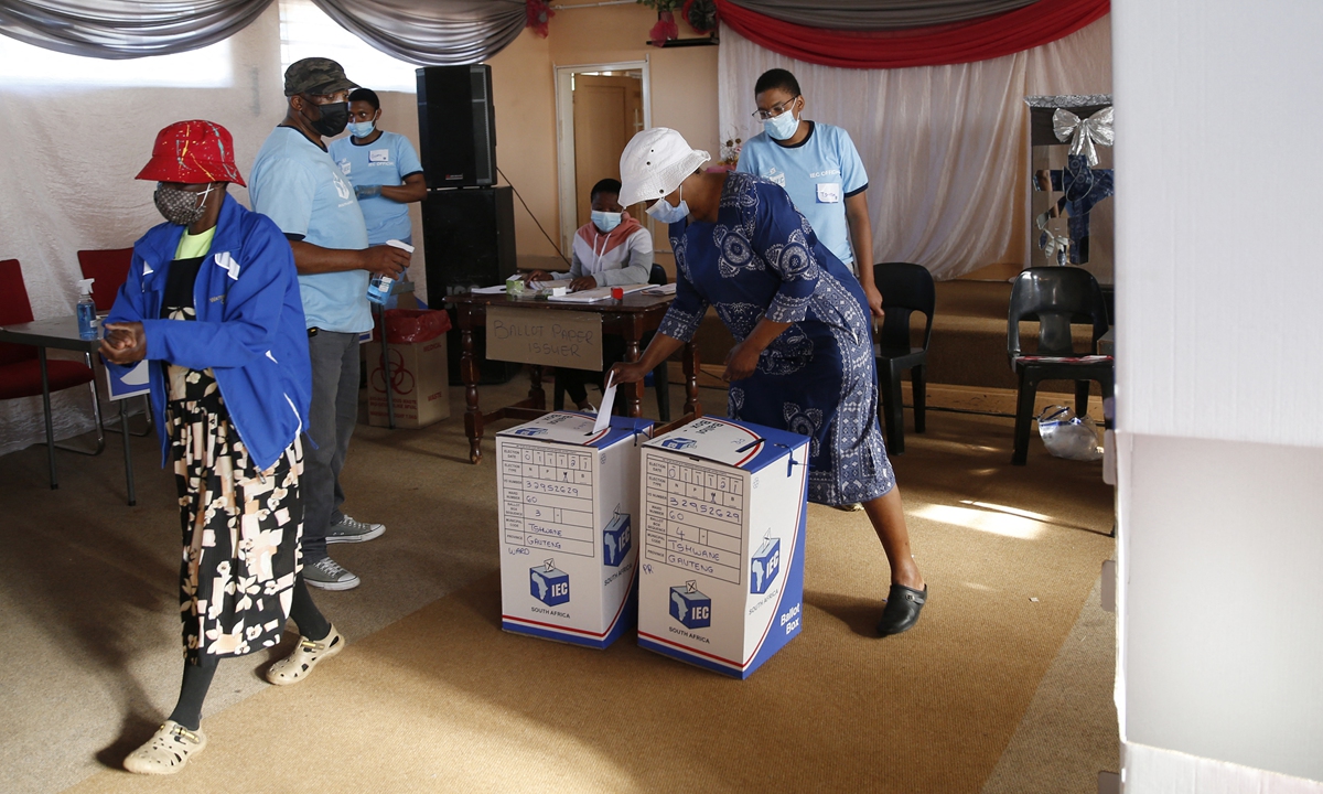 A voter (right) casts her ballot as another voter walks away after casting her ballot at a polling station in Danville, near Pretoria, South Africa on Monday, during South Africa's local elections. Photo: AFP