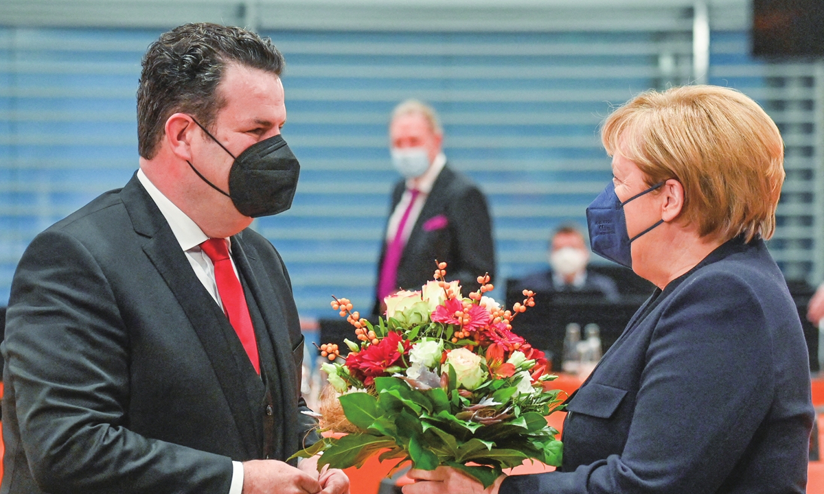 German Chancellor Angela Merkel (right) offers German Labor Minister and Deputy Chairman of Germany's Social Democratic Party SPD Hubertus Heil a bouquet of flowers on his birthday ahead of the start of the weekly cabinet meeting at the Chancellery in Berlin, on November 3, 2021. Photo: AFP