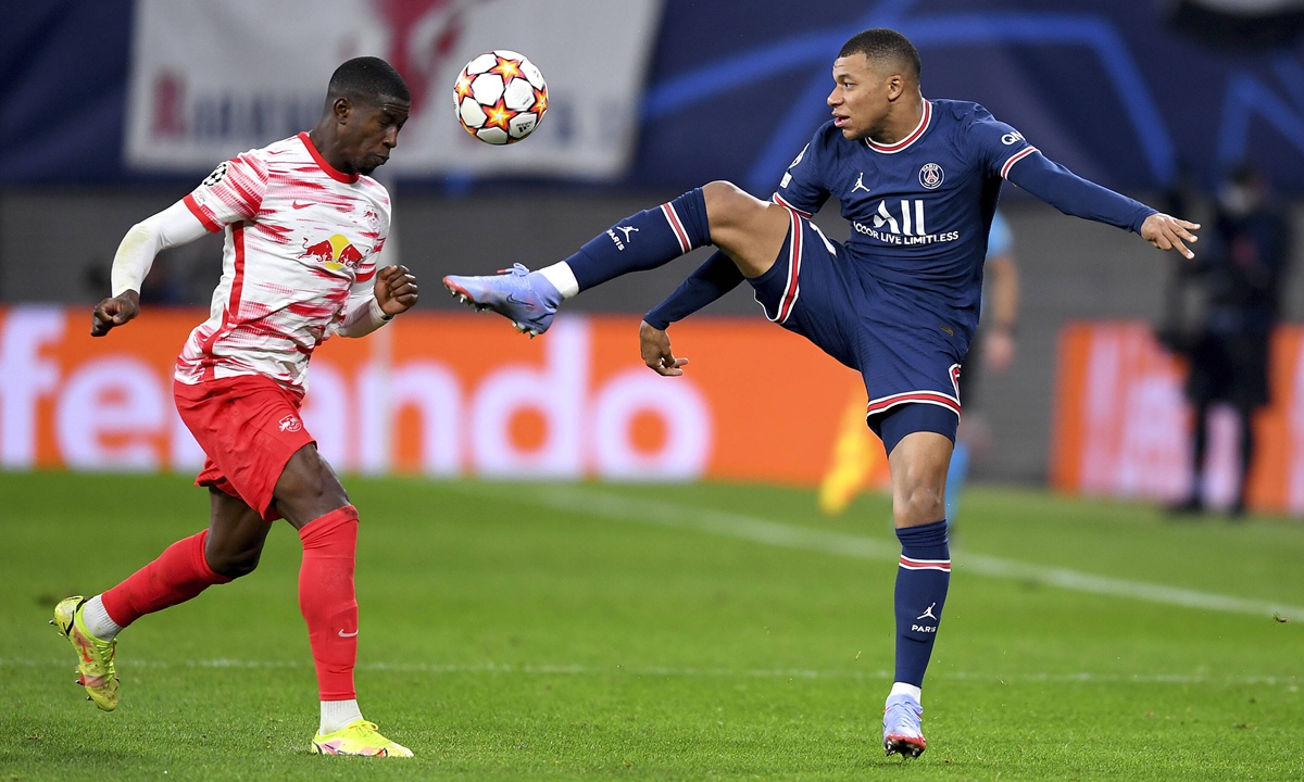 Nordi Mukiele of RB Leipzig (left) and Kylian Mbappe of PSG compete for the ball on Wednesday in Leipzig, Germany. Photo: VCG