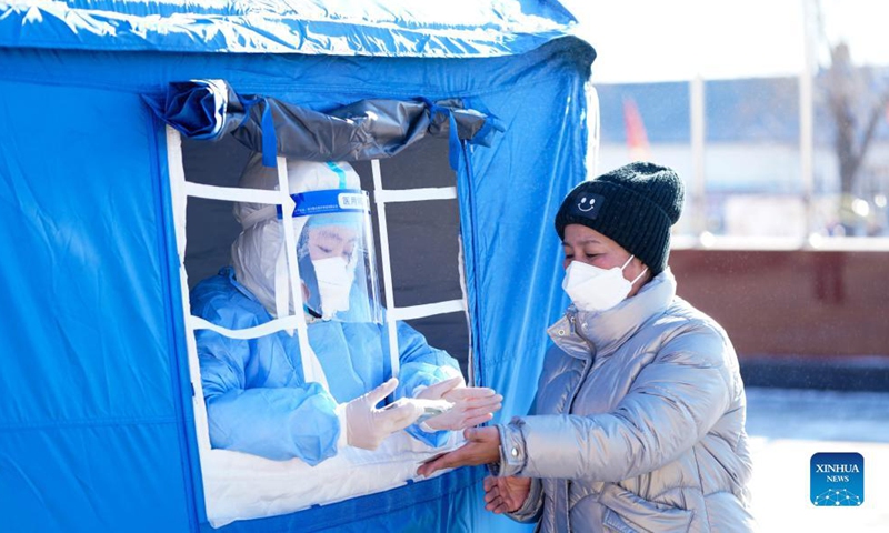 A medical worker prepares to take a swab sample from a resident for nucleic acid testing in Henantun Village of Xingfu Town in Heihe, northeast China's Heilongjiang Province, Nov. 7, 2021.Photo:Xinhua