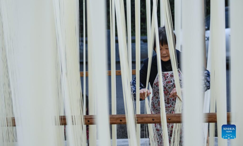 A villager dries handmade noodles in Huyuan Township of Fuyang District, Hangzhou City, east China's Zhejiang Province, Nov. 16, 2021. Noodle culture festival, noodle making activity, intangible cultural heritage performance and other events have been held in Huyuan Township in recent years, as efforts to promote the development of agricultural and rural tourism industries. Photo: Xinhua