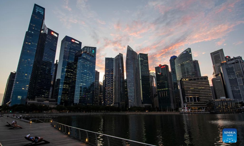 People enjoy the twilight view at Singapore's Marina Bay on Nov. 16, 2021. (Photo by Then Chih Wey/Xinhua) 