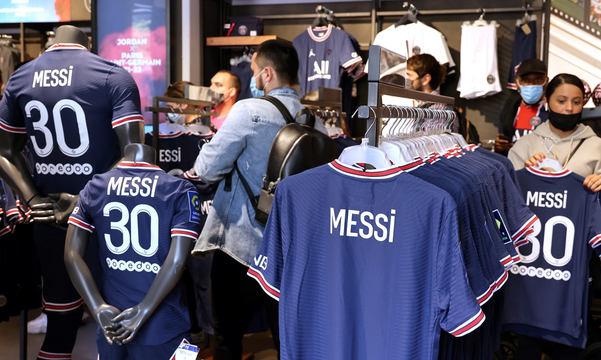  Paris Saint-Germain fans inspect Lionel Messi's No.30 shirts during Messi's press conference announcing his signing with the club in Paris on August 11. Photo: IC