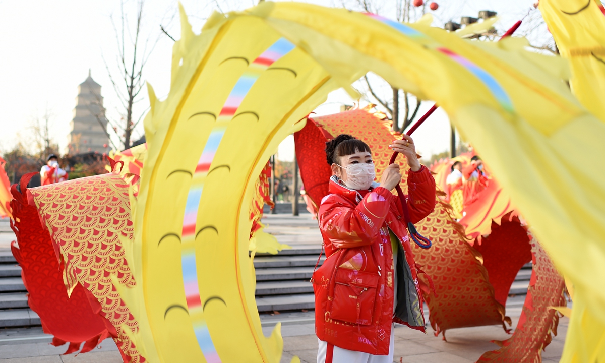 People in Xi'an, Northwest China's Shaanxi Province, perform a dragon dance amid a cold wave on November 22, 2021. The temperature on the same day in Xi'an ranged between -3 C and 7 C. From November 20-23, temperatures are expected to drop by 6 to 10 degrees from northwest to southeast China. Photo: VCG