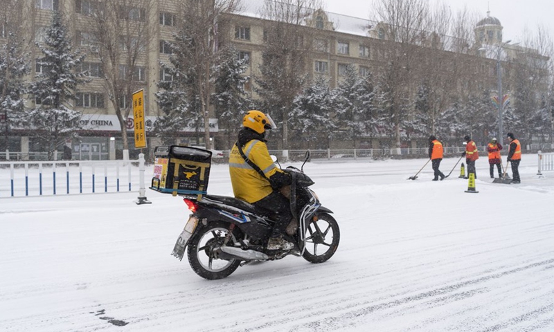 A courier rides on a snow-covered street in Hegang City, northeast China's Heilongjiang Province, Nov. 22, 2021.Photo:Xinhua