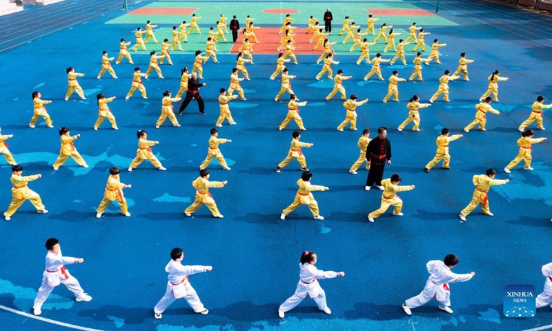 Photo taken on Nov. 30, 2021 shows students practising martial arts under the guidance of an inheritor of intangible cultural heritage in Zhaojiazhen Central Primary School in Zhuji city, east China's Zhejiang Province.This kind of martial art has a long history in Zhuji City and was included in the list of intangible cultural heritages in 2012.(Photo: Xinhua)