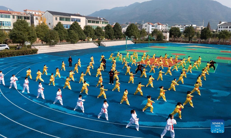 Photo taken on Nov. 30, 2021 shows students practising martial arts under the guidance of an inheritor of intangible cultural heritage in Zhaojiazhen Central Primary School in Zhuji city, east China's Zhejiang Province.This kind of martial art has a long history in Zhuji City and was included in the list of intangible cultural heritages in 2012.(Photo: Xinhua)