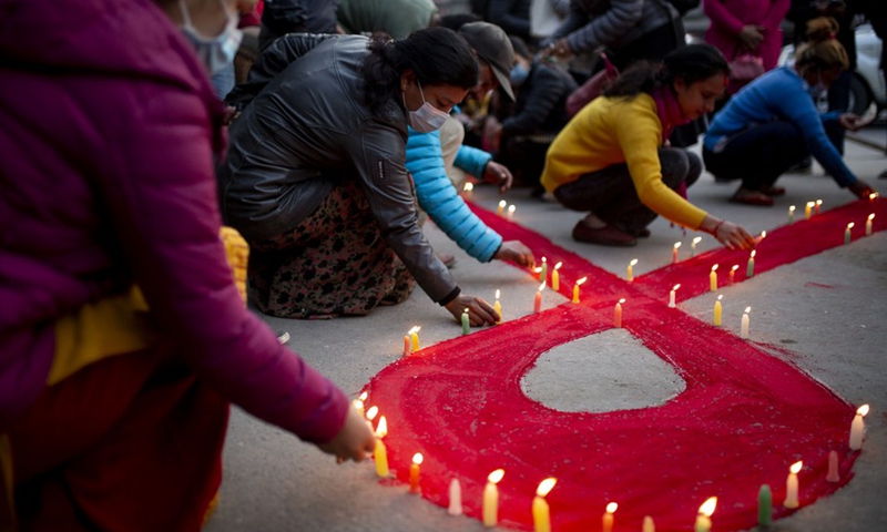 Volunteers light candles during an AIDS awareness campaign on the eve of World AIDS Day in Kathmandu, Nepal, Nov. 30, 2021.(Photo: Xinhua)