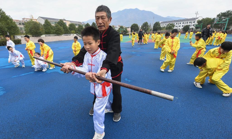 Photo taken on Nov. 30, 2021 shows students practising martial arts under the guidance of an inheritor of intangible cultural heritage in Zhaojiazhen Central Primary School in Zhuji city, east China's Zhejiang Province.This kind of martial art has a long history in Zhuji City and was included in the list of intangible cultural heritages in 2012(Photo: Xinhua)