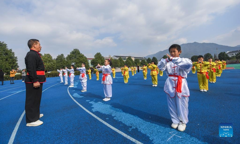 Photo taken on Nov. 30, 2021 shows students practising martial arts under the guidance of an inheritor of intangible cultural heritage in Zhaojiazhen Central Primary School in Zhuji city, east China's Zhejiang Province.This kind of martial art has a long history in Zhuji City and was included in the list of intangible cultural heritages in 2012.(Photo: Xinhua)