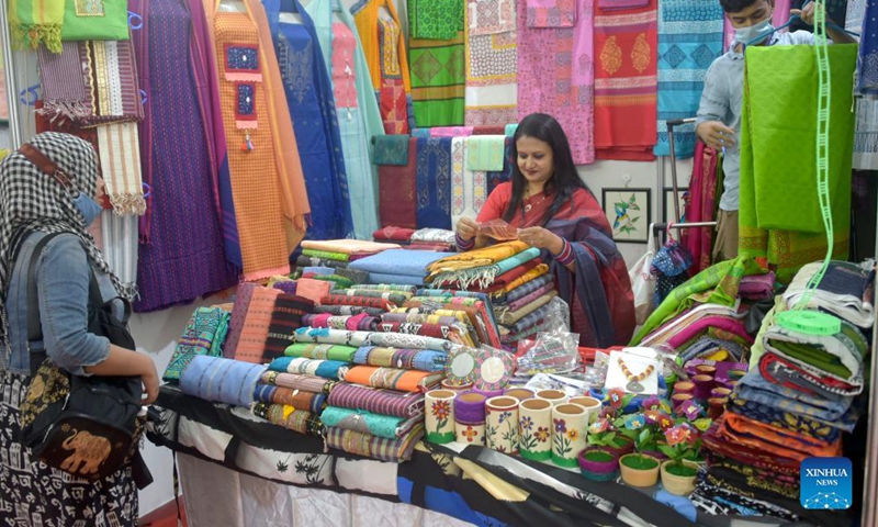 Exhibitors arrange products at a stall during Bangladesh's National Small and Medium Enterprise (SME) Fair in Dhaka, capital of Bangladesh, on Dec. 5, 2021.Photo:Xinhua