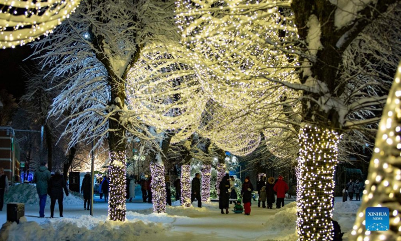 People enjoy Christmas lights in Ogre, Latvia, on Dec. 5, 2021.Photo:Xinhua