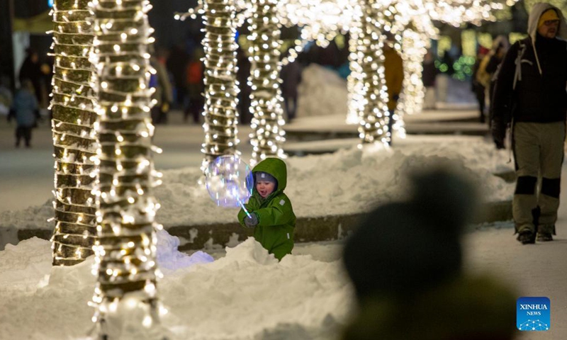 People enjoy Christmas lights in Ogre, Latvia, on Dec. 5, 2021.Photo:Xinhua