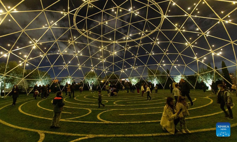 People are seen at Stavros Niarchos Foundation Cultural Center with festive lights in Athens, Greece, on Dec. 5, 2021.Photo:Xinhua