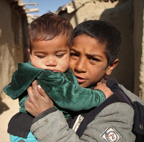 A displaced child holds his brother at an internally displaced persons (IDPs) camp in Kabul, capital of Afghanistan, on Nov. 20, 2021.(Photo: Xinhua)