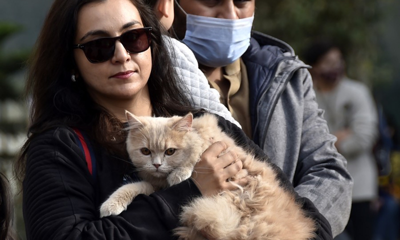 A woman carries her cat during a pet show in Peshawar, Pakistan, on Dec. 7, 2021.(Photo: Xinhua)