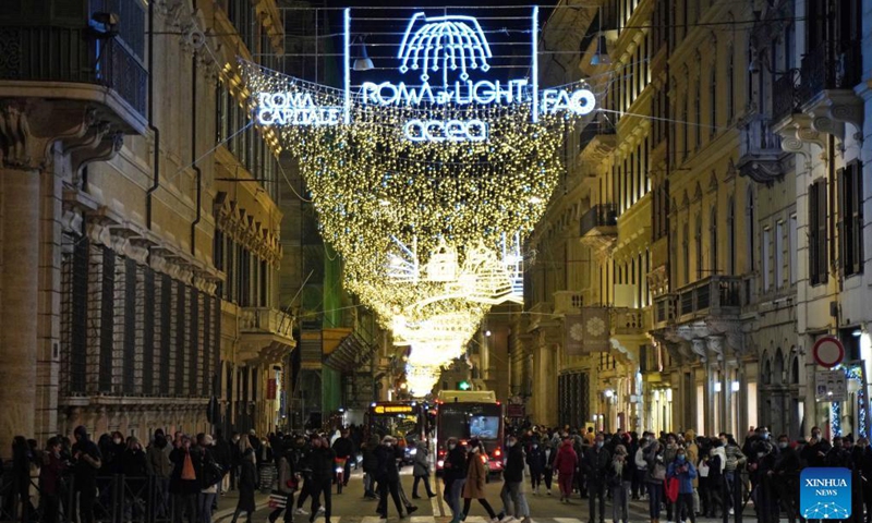 People walk on a street decorated with holiday lights in Rome, Italy, on Dec. 11, 2021. (Xinhua)