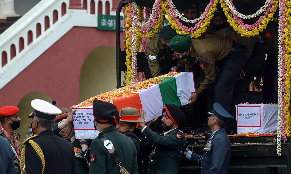 Army officers and soldiers carry the coffin of Indian Defense Chief General Bipin Rawat, who died a day earlier in a helicopter crash in Coonoor, during a military funeral at the Madras Regimental Center in Wellington, Tamil Nadu, on December 9, 2021. Photo:VCG