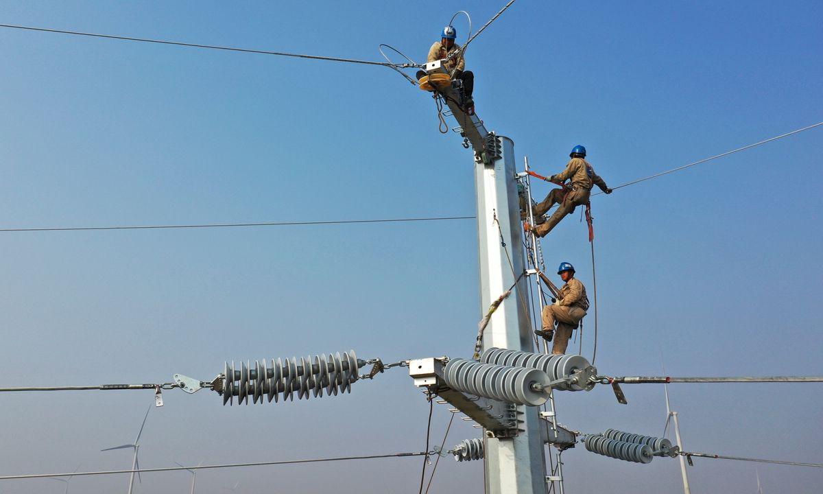 Workers carry out high-altitude wire-line operations in Suining county, East China's Jiangsu Province on December 9, 2021. The expansion of the power grid will alleviate local electricity problems and effectively guarantee electricity supply during the winter season. Photo: cnsphoto