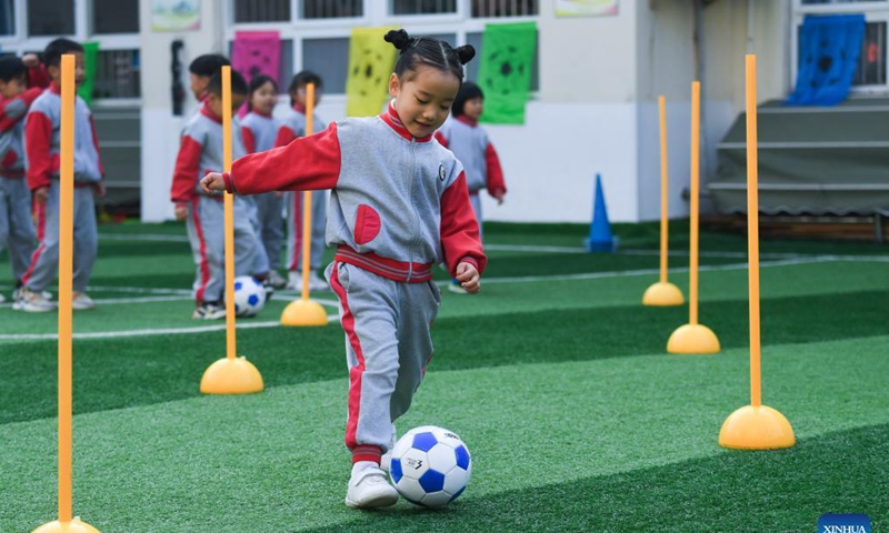 Photo taken on Dec. 8, 2021 shows kids participating in football skills competition. December 9 is World Football Day. In celebration of the event, Central Kindergarten in Changxing County, Huzhou City, east China's Zhejiang province held a week-long football festival, including activities such as dribbling the ball, shooting, running, and passing. Participating children enjoyed the day while learning new football skills. (Xinhua)