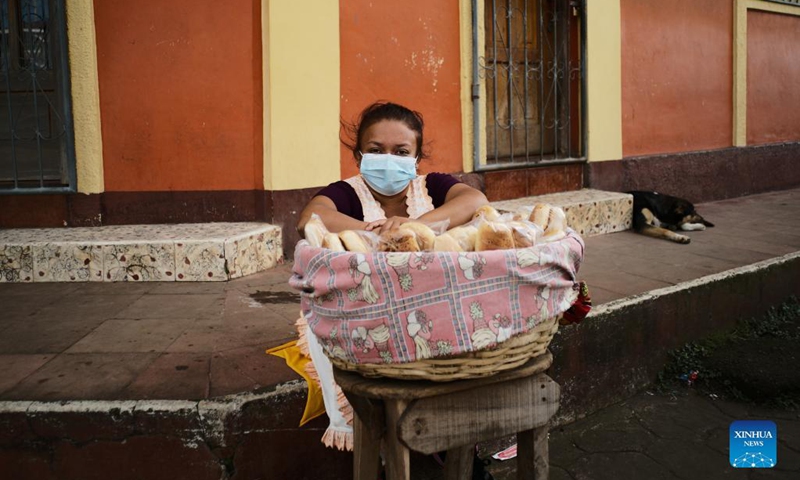 A woman is seen selling bread on a street in Masaya Department, Nicaragua on Dec. 12, 2021.(Photo: Xinhua)