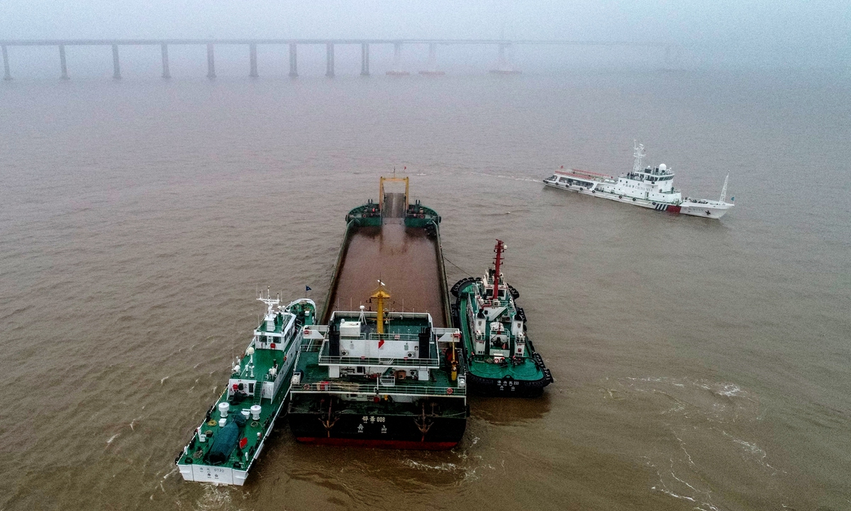 Marine police vessels in the Ningbo-Zhoushan Port surround a dry bulk cargo ship that 