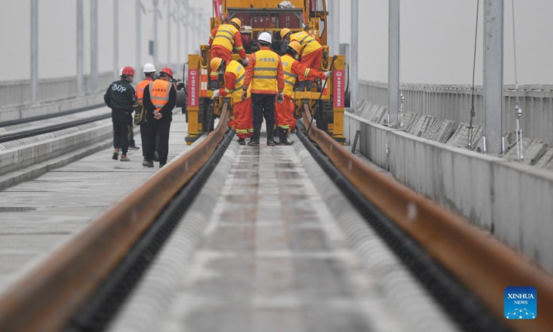 Workers of the China Railway No.4 Engineering Group lay the track of the Huzhou-Hangzhou high-speed railway in Yuhang District, Hangzhou City of east China's Zhejiang Province, Dec. 16, 2021.Photo:Xinhua