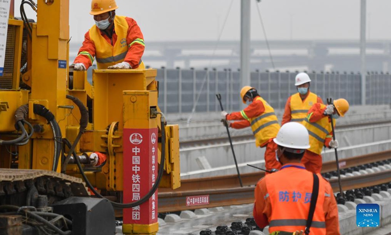 Workers of the China Railway No.4 Engineering Group lay the track of the Huzhou-Hangzhou high-speed railway in Yuhang District, Hangzhou City of east China's Zhejiang Province, Dec. 16, 2021.Photo:Xinhua