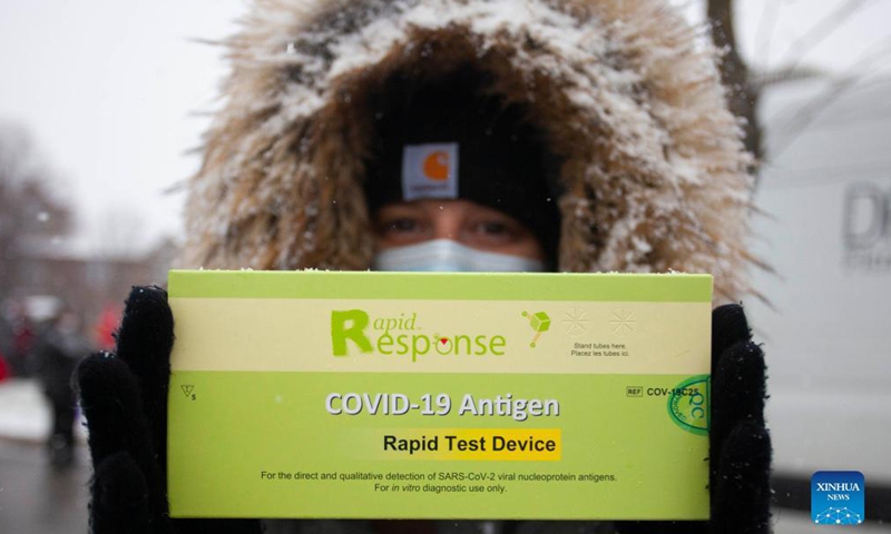 A woman wearing a face mask shows a free COVID-19 antigen rapid test kit she just received in Mississauga, Ontario, Canada, on Dec. 18, 2021.Photo:Xinhua