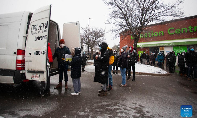 People wearing face masks line up to pick up free COVID-19 antigen rapid test kits in Mississauga, Ontario, Canada, on Dec.Photo:Xinhua