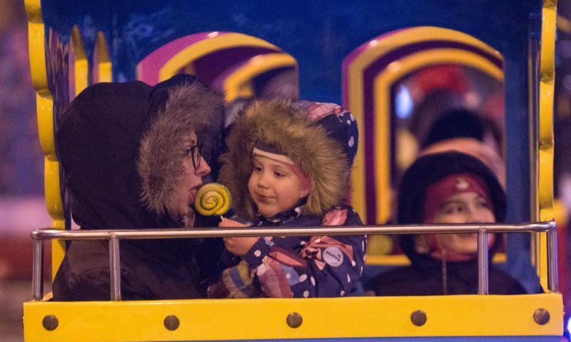 Children enjoy themselves on a tourist train at the Christmas market in St. Petersburg, Russia, Dec. 18, 2021.Photo:Xinhua