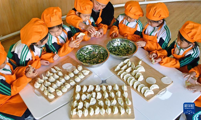 Children learn to make dumplings in celebration of the Winter Solstice or Dongzhi in their kindergarten in Yantai, east China's Shandong Province, Dec. 20, 2021. Winter Solstice, the shortest day of the year, falls on Dec. 21 this year. In Chinese culture, it marks the beginning of deep winter. It is also a time for family gatherings.(Photo: Xinhua)