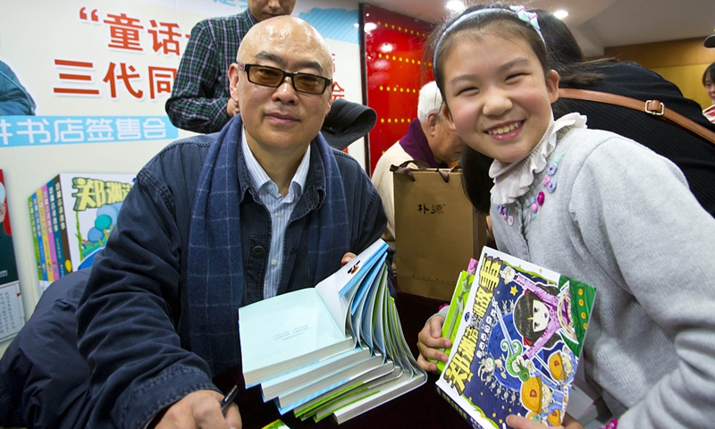 Zheng Yuanjie with a young reader on December 8, 2013 in Beijing Photo: VCG