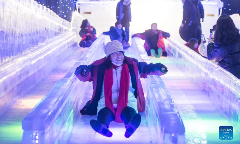 Visitors play on an ice slide at an ice and snow art festival in Wuhan, capital of central China's Hubei Province, Dec. 21, 2021. As part of the 8th National Public Ice and Snow Season, the ice and snow art festival kicked off here on Tuesday.(Photo: Xinhua)