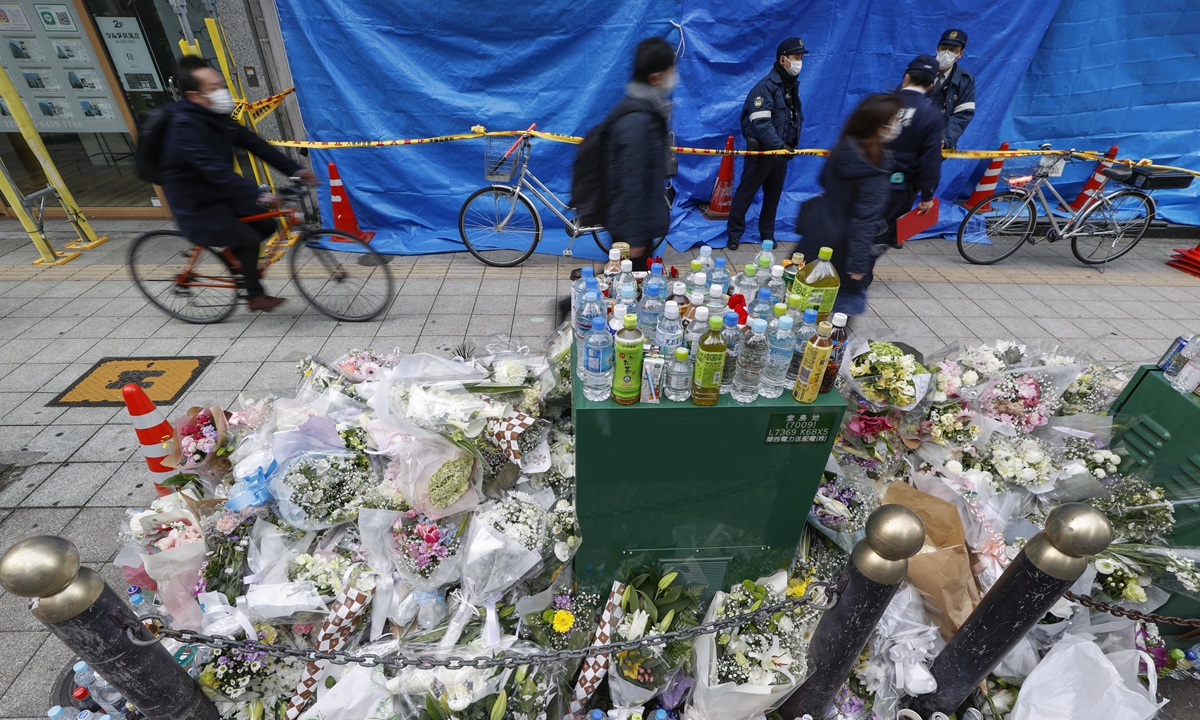 The photo taken on December 22, 2021 shows flowers placed in front of a multiple tenant building recently hit by a deadly fire in Osaka, Japan. A 61-year-old male patient of a mental clinic in the building is suspected of starting the fire on December 17 that killed more than 20 people. Photo: VCG