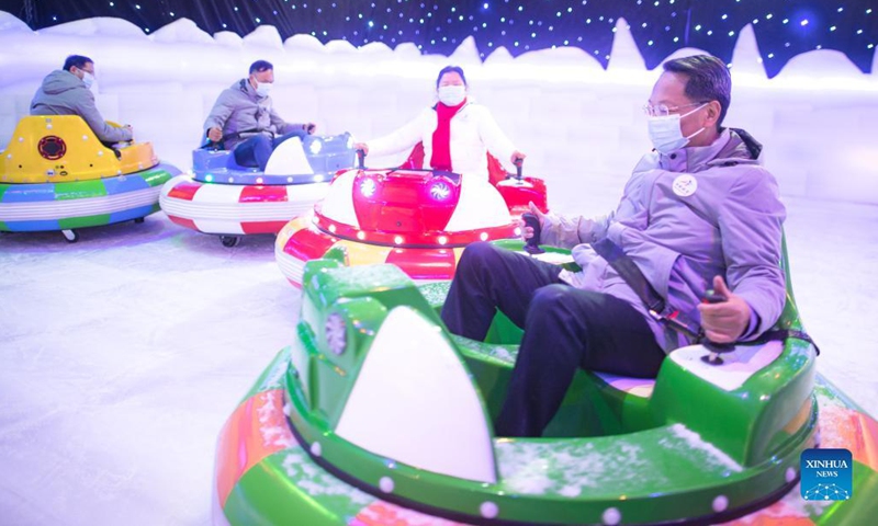 Visitors play bumper cars at an ice and snow art festival in Wuhan, capital of central China's Hubei Province, Dec. 21, 2021. As part of the 8th National Public Ice and Snow Season, the ice and snow art festival kicked off here on Tuesday.(Photo: Xinhua)