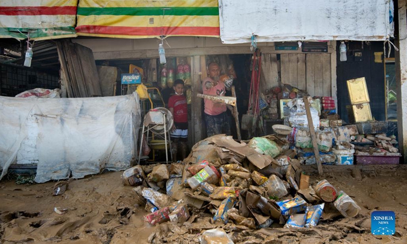 Local residents clear up mud and debris after flood hit in Hulu Langat of Selangor state, Malaysia, Dec. 21, 2021. Another nine people have been reported dead, bringing the total deaths due to severe flooding in Malaysia to 17 as of Tuesday, authorities in Selangor state said.(Photo: Xinhua)