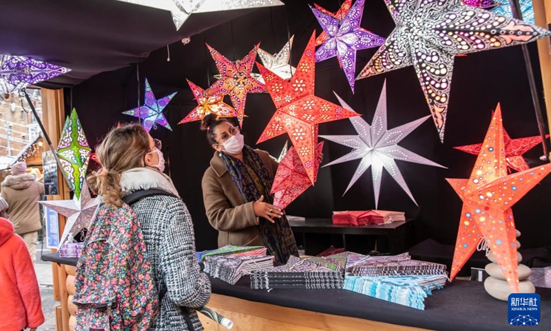 A woman shops at the Christmas market in Lille, northern France, Dec. 22, 2021.(Photo: Xinhua)