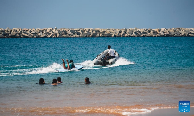 People enjoy their leisure time in the sea near the artificial beach in Colombo's Port City, Sri Lanka, Dec. 21, 2021. (Xinhua/Tang Lu)