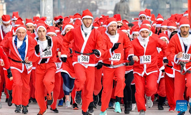 People dressed as Santa Claus take part in the annual city race in Skopje, North Macedonia on Dec. 26, 2021. (Photo by Tomislav Georgiev/Xinhua)