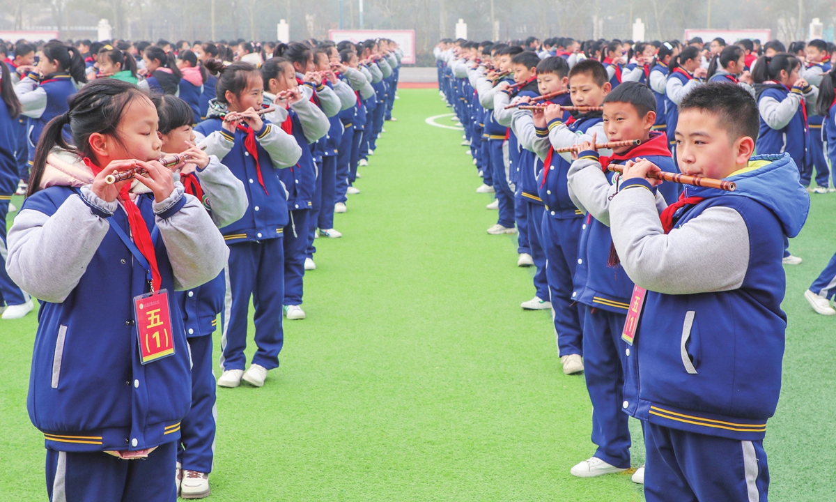 Students in a school at Lianyungang, East China's Jiangsu Province, play bamboo flutes, cultivating interest in traditional culture on December 27,2021. Photo: IC
