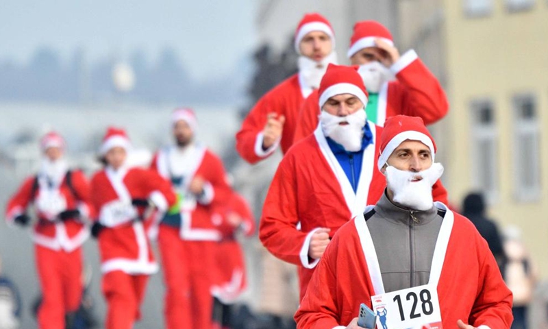 People dressed as Santa Claus take part in the annual city race in Skopje, North Macedonia on Dec. 26, 2021. (Photo by Tomislav Georgiev/Xinhua)