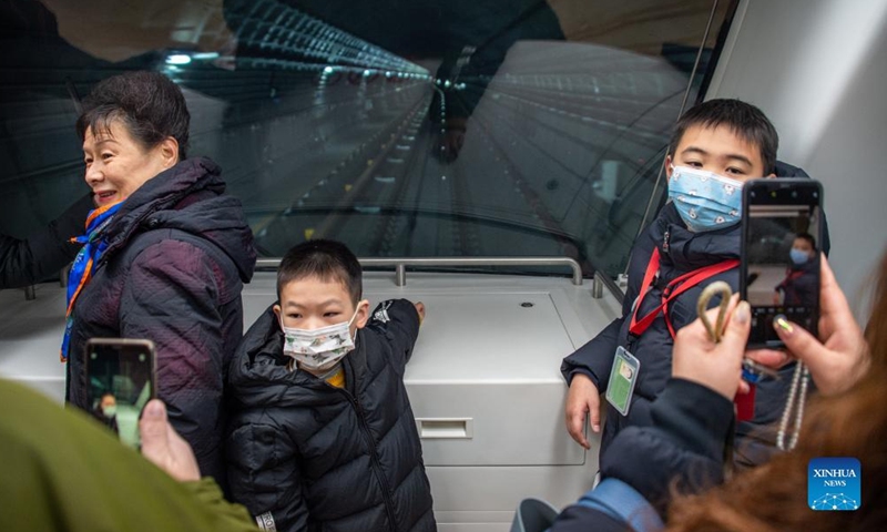 Passengers pose for photos on the first carriage of a train of the Metro Line 5 in Wuhan, central China's Hubei Province, Dec. 26, 2021.Photo:Xinhua