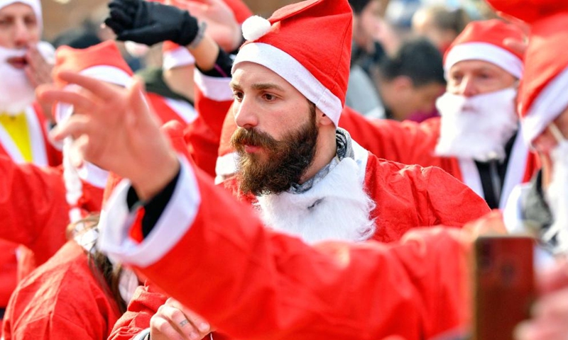 People dressed as Santa Claus take part in the annual city race in Skopje, North Macedonia on Dec. 26, 2021. (Photo by Tomislav Georgiev/Xinhua)