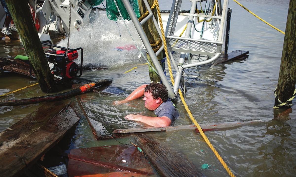 A shrimper works to salvage a shrimp boat that was partially submerged by Hurricane Ida in Golden Meadow, Louisiana, US, on August 31, 2021.Photo: VCG