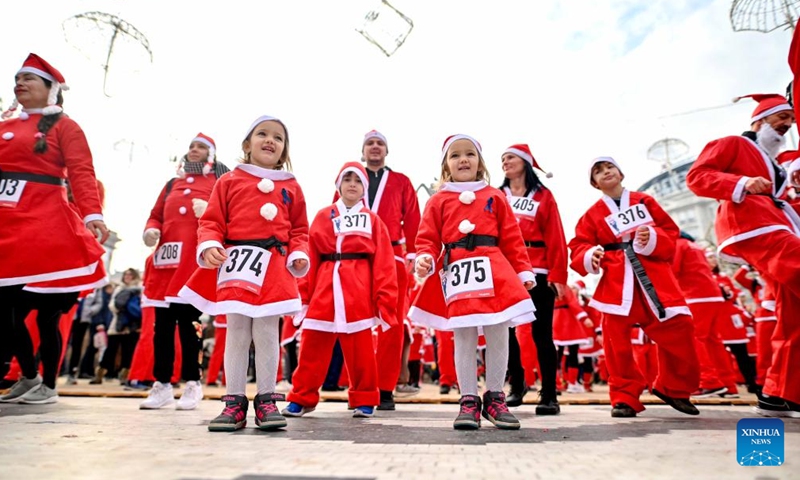 People dressed as Santa Claus take part in the annual city race in Skopje, North Macedonia on Dec. 26, 2021. (Photo by Tomislav Georgiev/Xinhua)