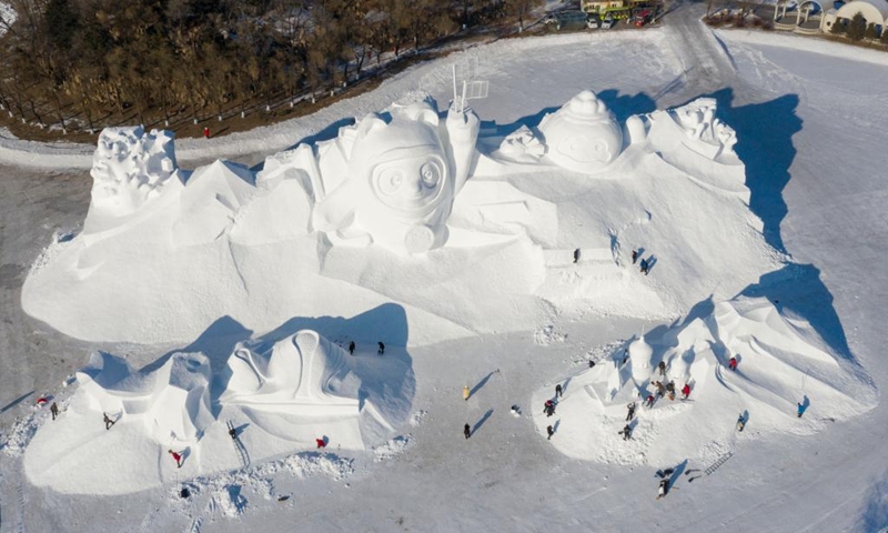 Aerial photo taken on Dec. 28, 2021 shows workers finishing the main snow sculpture featuring Beijing 2022 mascots at the 34th Harbin Sun Island International Snow Sculpture Art Exposition in Harbin, northeast China's Heilongjiang Province. (Xinhua/Xie Jianfei)